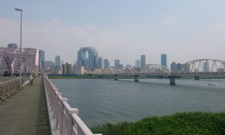 よく晴れた暑い午後に淀川大橋を歩いて渡る