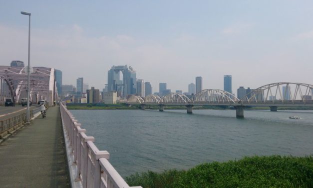よく晴れた暑い午後に淀川大橋を歩いて渡る